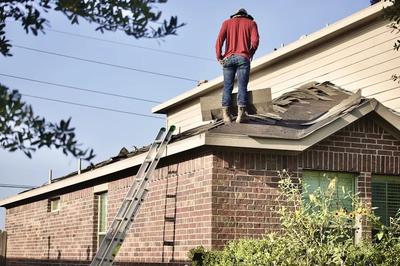 Professional roofer working on a residential roof in Earl